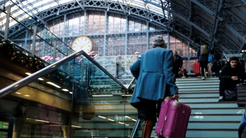 A passenger walking up stairs at St Pancras station