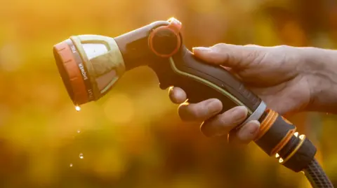 A hand holding a hosepipe gun