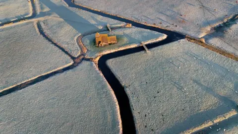 PA An aerial photo showing St Thomas Becket church surrounded by frosty fields on the Romney Marsh in Kent