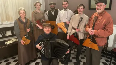 Handout Seven members of the Kalinka Balalaika Orchestra in traditional Eastern European costumes pose with their instruments 