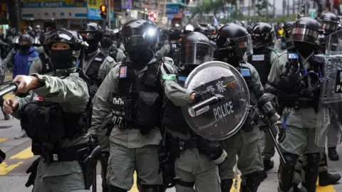 Getty Images Riot police stand against demonstrators during a protest in the Wan Chai district of Hong Kong, China, on January 1, 2020.