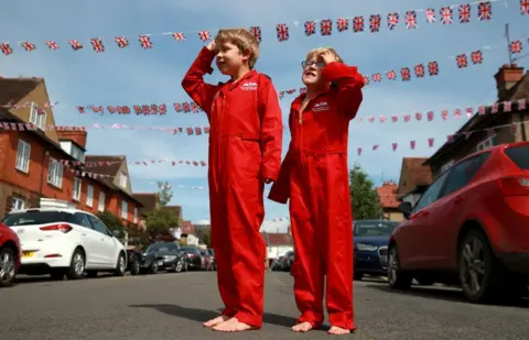 Getty Images Max Panton, seven, and his five-year-old brother Theo joined the silence wearing their replica RAF Red Arrows uniforms