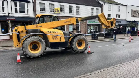 Qays Najm/BBC A yellow JCB cordoned off by police tape