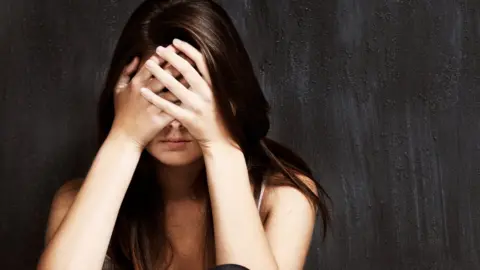 PeopleImages/Getty Images Woman with head in hands