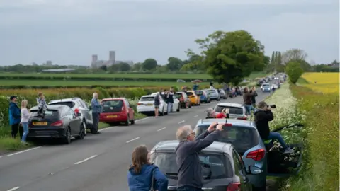 Joe Giddens/PA People fill the road as the UK's only airworthy Lancaster bomber, PA474, passes over Lincoln Cathedral