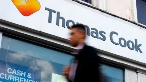 Getty Images A pedestrian walks past a closed branch of a Thomas Cook travel agent's shop in London