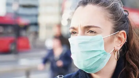 Getty Images Woman wearing a face mask