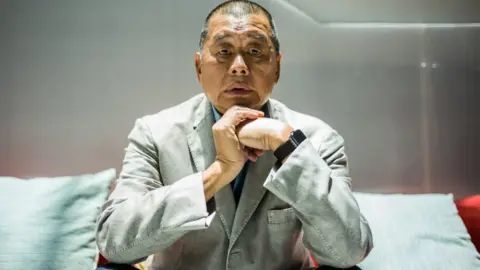 Getty Images Jimmy Lai poses during an interview with the AFP news agency at the offices of now defunct newspaper Apple Daily