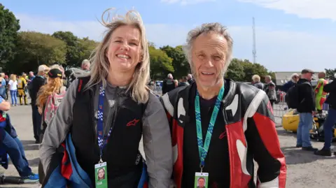 Rob and Dafne, who are standing in front of a crowd at the event, are smiling for the camera. 