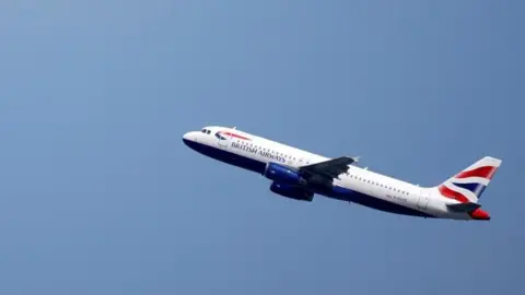 A British Airways Airbus A320 flies up through a blue sky.