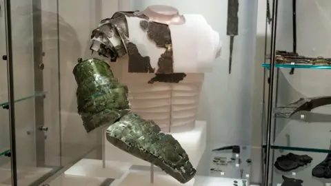 Duncan McGlynn/NMS A museum display with a partially reconstructed arm guard and breast plate from the Roman era in a glass cabinet