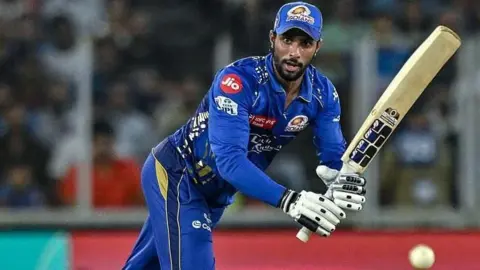 Tilak Varma watches the ball as he hits it through mid-wicket during an IPL game