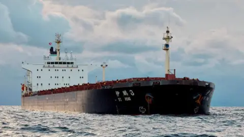 Reuters Chinese ship Yi Peng Three in the Kattegat strait off Denmark. It has a black hull and is a cargo ship, so its body is long and low. 