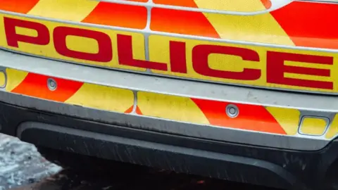 Generic image of a police vehicle. The close-up shows the back of the vehicle with the word "police" in red letters.
