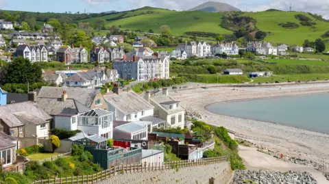 Getty Images Criccieth in Gwynedd. Houses on rolling green hills overlook a pebble beach