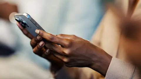 A stock photo of a woman texting on a mobile phone.