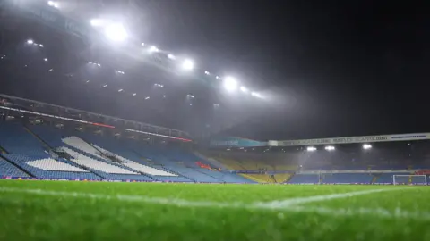 Getty Images An empty and floodlit Elland Road stadium, pictured in the dark.