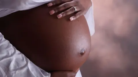 Getty Images A close-up photo of a woman's pregnant stomach.