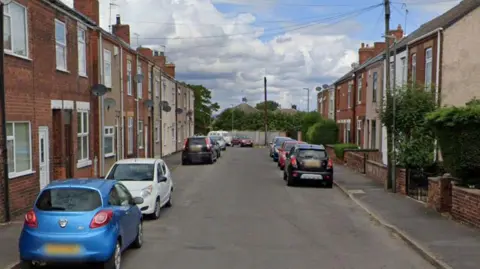Google A street view image of cars parked on Henry Street in Grassmoor, Derbyshire.