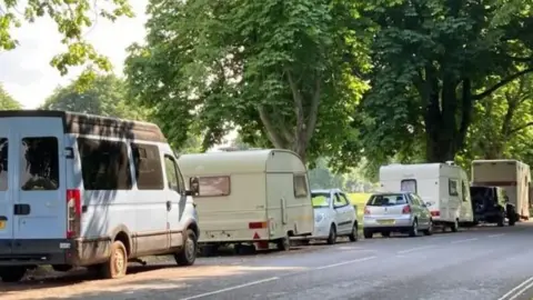 A number of vans parked along the edge of the Downs in Bristol