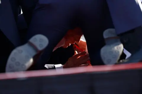 Getty Images Republican presidential candidate former President Donald Trump is rushed offstage during a rally on July 13, 2024 in Butler, Pennsylvania. 