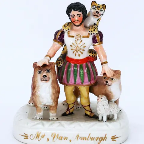 Browns Auction House A Staffordshire pottery figure of a colourfully-dressed lion tamer with a leopard round his neck, lions at his side and a lamb at his feet