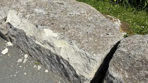 Two rocks with more stone chips next to them.