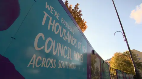 A board reads: We're building thousands of new council homes across Southwark