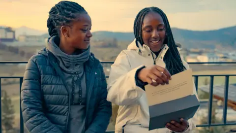 Sisters Elizabeth and Letitia, from West Sussex, pictured during this year's Race Across the World. Elizabeth is wearing a black jacket, while Letitia is wearing a white jacket and holding a piece of paper. 