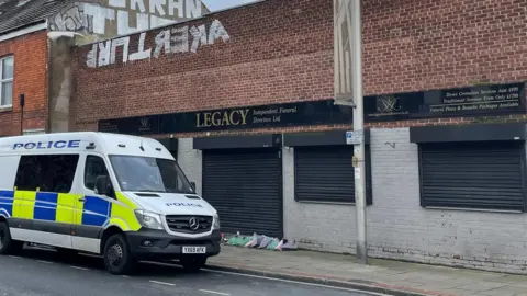 Dave Higgens/PA Media Police van outside a funeral directors premises