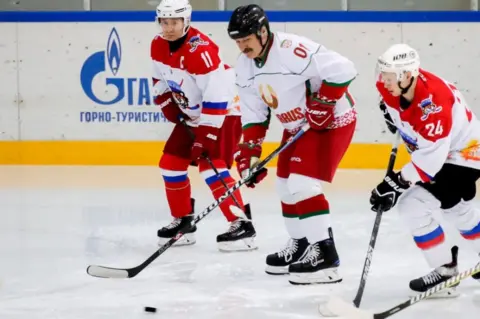 Getty Images Alexander Lukashenko (C) and Vladimir Putin (L) in a friendly ice hockey match in Sochi, Russia