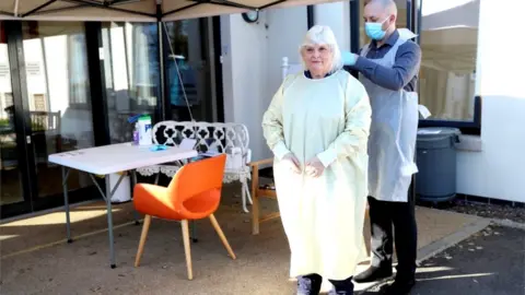 PA Media Fiona Scott puts PPE on