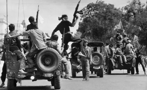 AFP/Getty Images The Khmer Rouge guerilla soldiers wearing black uniforms (C), drive 17 April 1975 atop jeeps