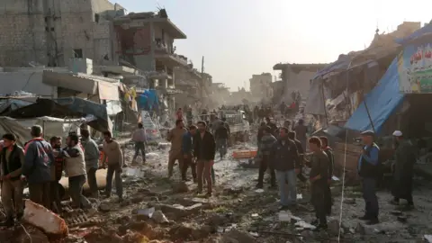 AFP Aftermath of a reported air strike on a market in the rebel-held town of Atareb in northern Syria on 13 November 2017