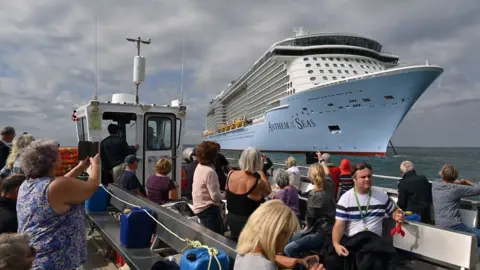 AFP small boat of sight-seekers looking at big cruise ship