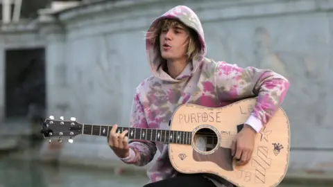 Getty Images Justin stops at the Buckingham Palace fountain to sing songs for Hailey on a trip to London in September.