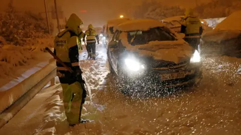 Reuters Firefighters help stranded drivers in Madrid