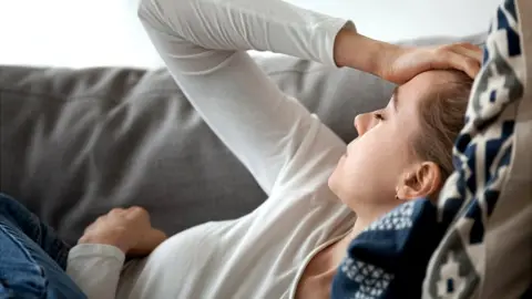 Tired woman lying on a sofa