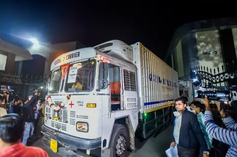 AFP Media personnel surround a refrigerator truck before leaving the Serum Institute of India with vials of Covishield vaccine in Pune early on January 12, 2021.