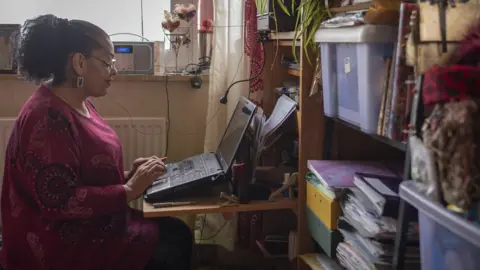 Phil Coomes/BBC Ruby at her laptop, where she writes her poetry
