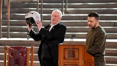 Pool via Reuters Speaker of the House of Commons, Sir Lindsay Hoyle holds the helmet of one of the most successful Ukrainian pilots, inscribed with the words "We have freedom, give us wings to protect it", which was presented to him by Ukrainian President Volodymyr Zelensky as he addressed parliamentarians in Westminster Hall