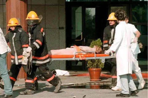 DRASKO GAGOVIC/EPA Unidentified injured Chinese embassy staff is carried away on a stretcher by Yugoslav rescue workers after the fire at the Chinese embassy, early Saturday, 08 May 1999,