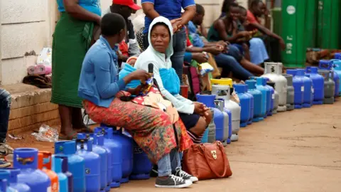 Reuters Two women queue for gas