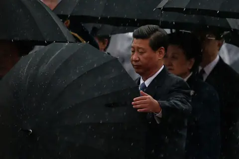 Getty Images Chinese President Xi Jinping (Left) opens his umbrella, 2013
