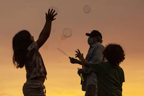Etienne Laurent / EPA A man makes soap bubbles on California's Venice Beach
