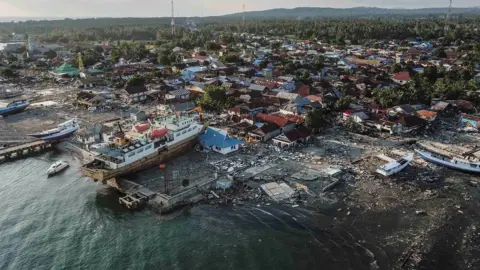 Indonesia earthquake and tsunami: Dead buried in mass grave