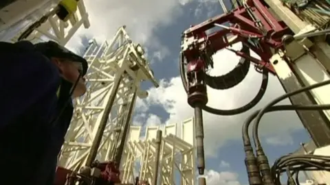 BBC Man looking up at fracking equipment