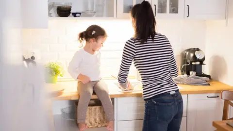 Getty Images Woman prepares food with her daughter