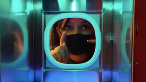 A woman conducting a business meeting through a glass partition