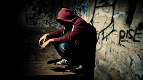 Getty Images Anonymous teenager in dark corner